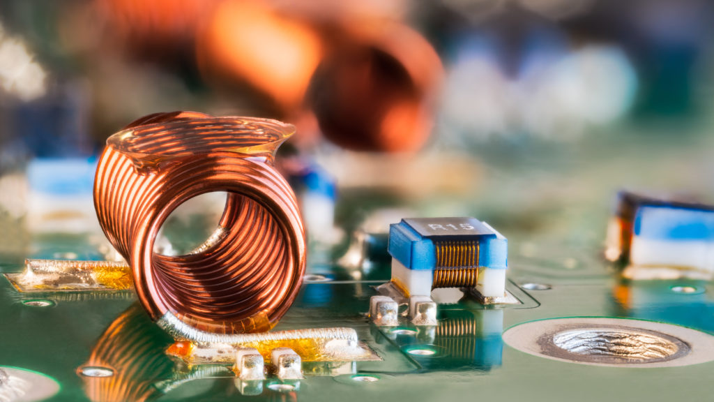 Closeup photograph of radio frequency inductor, small capacitors and resistors on printed circuit board. Surface mount technology